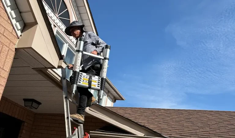 首页-Toronto Roofing Contractor | King Roofing & Construction Exterior technician working along a home's soffit and siding